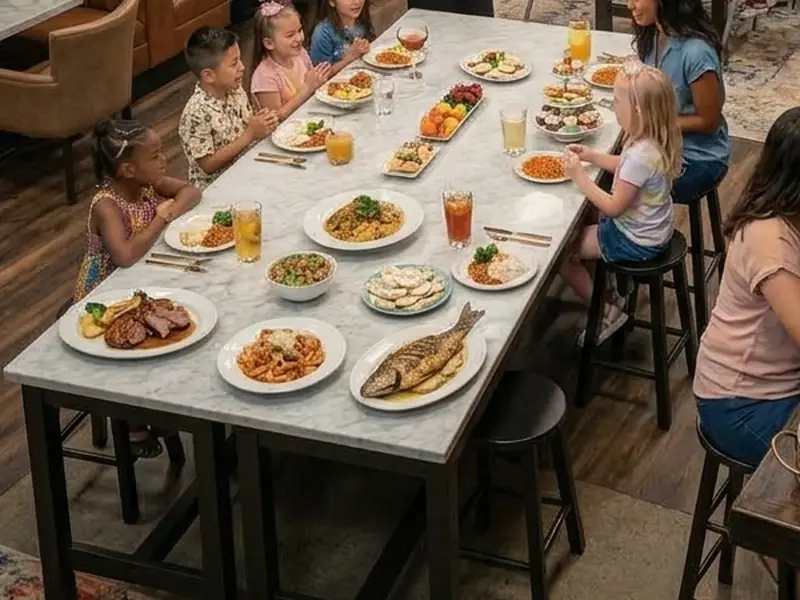 Kids sharing a long table full of colourful dishes and drinks